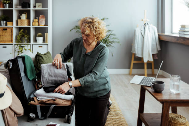 istock Woman preparing for road trip, packing suitcase 1385955596