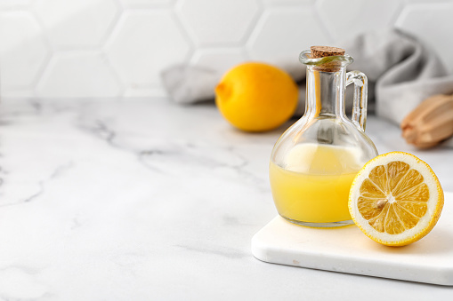 Lemon juice Freshly squeezed on a marble table full and ripe lemons. Copy space