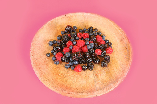 red fruits: blueberries, raspberries and blackberries in wooden