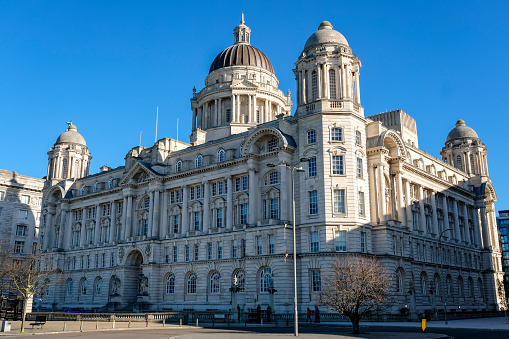 5th March 2022: View from Pier Head dock, of the iconic Port of Liverpool building, known as one of the Three Graces. The imposing office building is located by Pier Head in the busy docklands area of the city. Designed by Sir Arnold Thornely and F.B. Hobbs for the Mersey Docks & Harbour Board, the building was completed in 1907 and is now the office space for numerous companies.