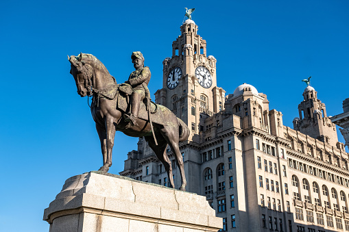 5th March 2022: Edward VII monument in the Pier Head dock in Liverpool. A life-size bronze statue on a stone plinth. Designed by  sculptor Sir William Goscombe John in 1916 and unveiled in 1921 in memory of the King. The Royal Liver Port building is in the background, once the headquarters for the Royal Liver Assurance Group when it was built in 1911.
