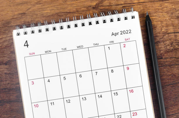 istock April 2022 desk calendar on wooden table. 1385966184