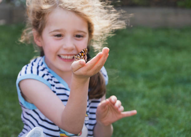 istock Happy Girl Holding a Butterfly 1385969616