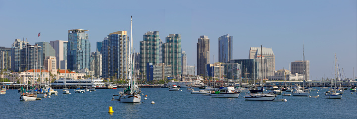 Daytime panoramic view of the San Diego skyline and recreational boats in San Diego bay.