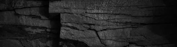 Photo of Black and white rock texture. Crushed mountain surface. Close-up. Grunge backdrop. Dark gray stone background.