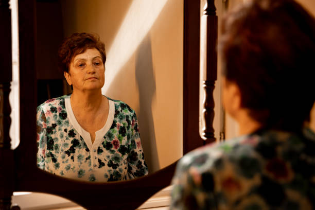 istock Confident senior lady looking her reflection in the mirror 1385973188