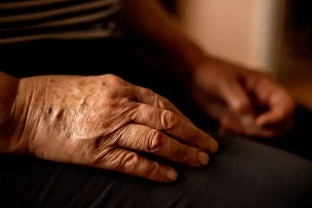 Close up view of the old and wrinkled hands of the unrecognizable Caucasian senior woman