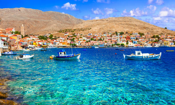 villages de pêcheurs traditionnels de la grèce - charmante île de chalki (halki) en dodécanèse. vue avec des bateaux typiques et des maisons colorées - aegean islands photos et images de collection