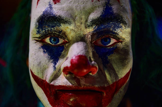 Creepy Evil Clown Mannequin Face Close Up Image High Resolution Against a dark background. stock photo