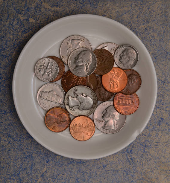 small american coins on a white saucer stock photo