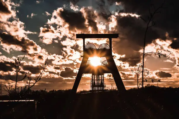 Picture of a winding tower from a Colliery in Germany with the sunset shining through