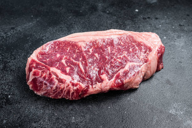 istock Raw Striploin steak, beef butchery cut. Black background. Top view 1385982418