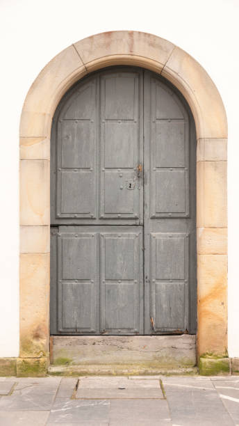istock Old arched wooden door in facade 1385984953