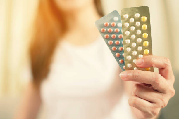 Woman hands opening birth control pills in hand. eating Contraceptive pill. Contraception reduces childbirth and pregnancy concept. Leave space to write descriptive text. Woman hands opening birth control pills in hand. eating Contraceptive pill. Contraception reduces childbirth and pregnancy concept. Leave space to write descriptive text. oestrogen stock pictures, royalty-free photos & images