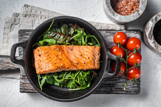 filetes de salmón, filetes a la plancha en sartén con hierbas. fondo blanco. vista superior - baked salmon fotografías e imágenes de stock