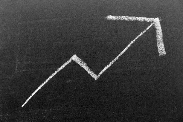 istock White color chalk hand drawing in shape on black board background (Concept of stock or price increase, up trend of business, economy) 1385985709