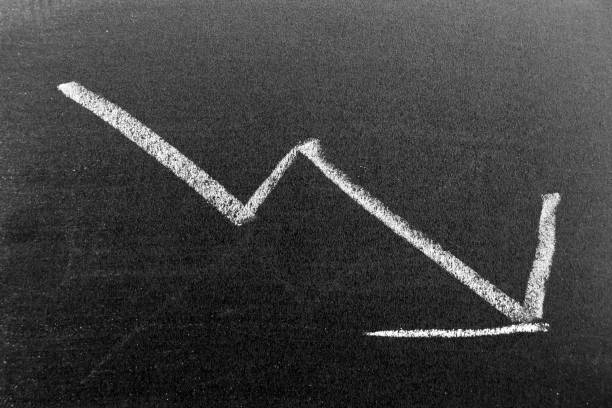 istock White color chalk hand drawing in arrow down shape on black board background (Concept of stock decline, down trend of business, economy) 1385985780