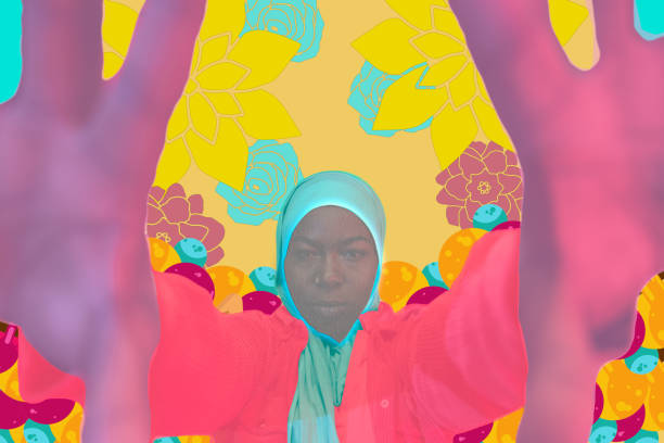 A colourful portrait of a young woman holding her hands up to the camera. There is art surrounding her in the image.