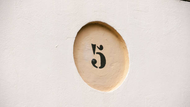 istock Number 5 in round molding in stucco wall 1385988404