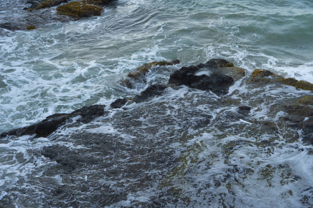 istock Sea waves lash line impact rock on the beach 1385997427