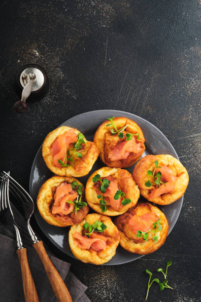istock Yorkshire pudding. Traditional English Yorkshire pudding with salmon and radish microgreens side dish on dark grey plate and dark background table. Top view. 1385999344