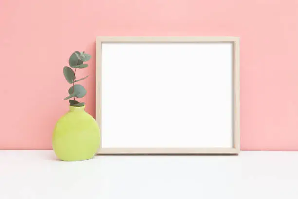 Mockup of a thin wooden frame. A stylized image of a thin horizontal frame on a table. Minimalistic frame layout.