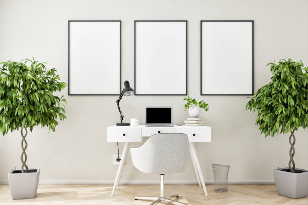 istock Three blank picture frame mockups on a beige structured wall with a writing desk, chair, notebook, books, desk lamp and two fig trees . 1386001373