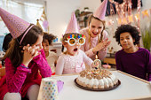 istock Little girl blowing her birthday candle 1386004014
