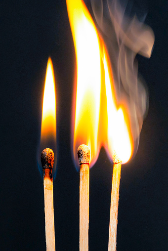 Fire and smoke. Burning and smoking match on a black background. Heat and light from fire flame