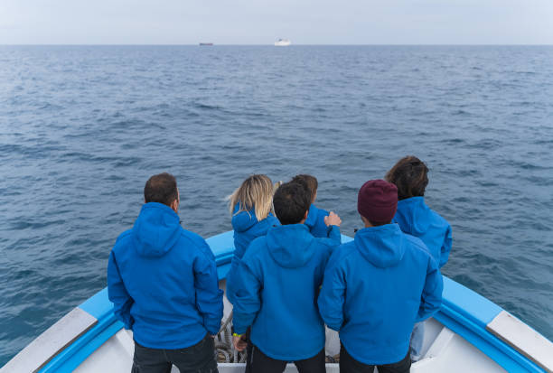 istock Crew members in blue uniforms standing on a boat 1386009872