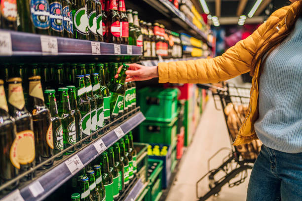 kunde, der bier im spirituosengeschäft kauft - alcohol stock-fotos und bilder