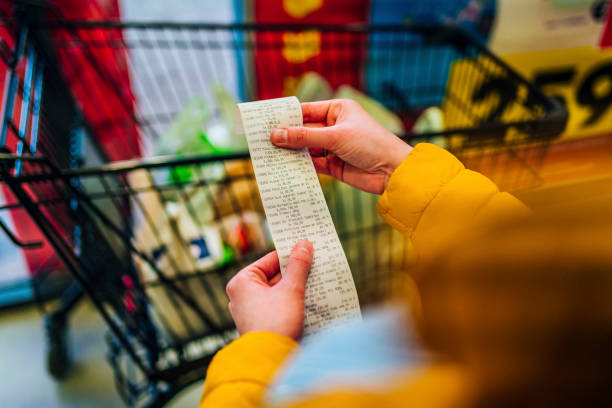 Checking the bill Woman checking the bill when paying at a supermarket buying stock pictures, royalty-free photos & images