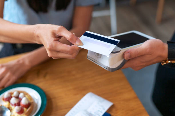 Nfc contactless payment by credit card and pos terminal Contactless payment concept, female customer holding credit card near nfc technology on counter, client make transaction pay bill on terminal rfid cashier machine in restaurant store, close up view contactless airport stock pictures, royalty-free photos & images