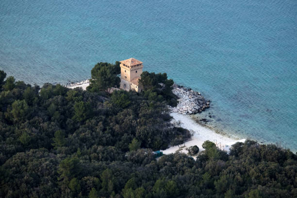 A view from Conero mt. of portonovo bay with a tower surrounded by trees