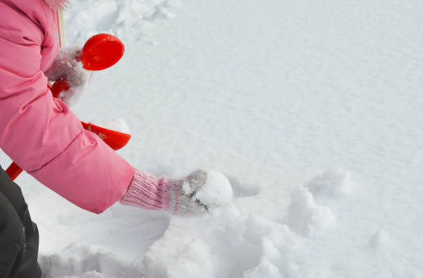 istock fun winter games in the snow, modeling snowballs. 1386029625