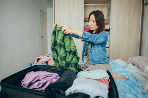 istock Woman packing a suitcase on bed for a trip 1386030946
