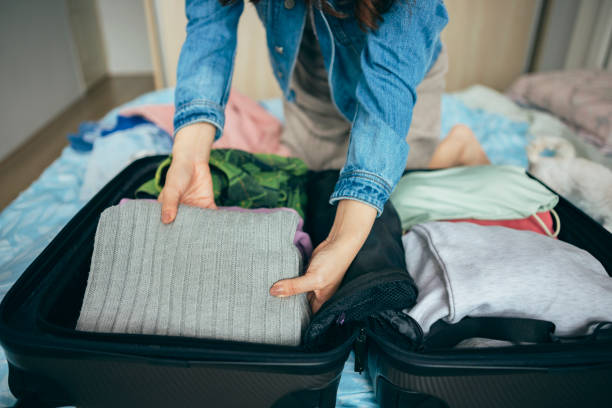 istock Woman packing a suitcase on bed for a trip 1386030963