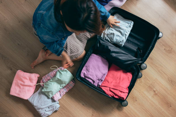 istock Woman packing a suitcase on bed for a trip 1386031075