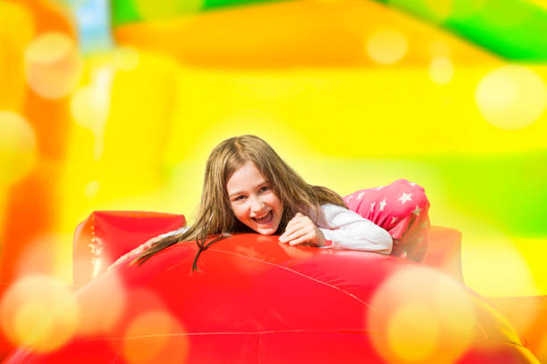 istock Happy Girl on Inflate Yellow Castle 1386032198
