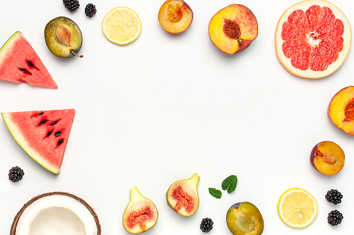 Tropical Summer Fruit Concept. Creative layout made of fresh ripe watermelon, peach, plum, fig, lemon, grapefruit and mint leaves on white background. Flat lay, top view, copy space. Food background.