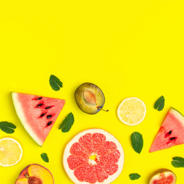 istock Tropical Summer Fruit Concept. Creative layout made of fresh ripe watermelon, peach, plum, fig, lemon, grapefruit and mint leaves on yellow background. Flat lay, top view, copy space. Food background 1386033913