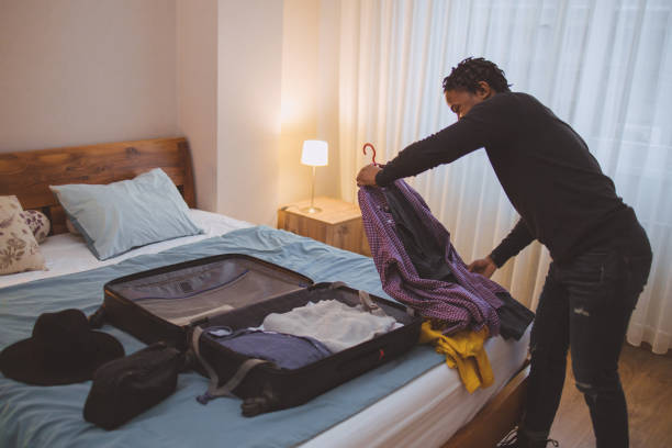 un jeune homme afro-américain faisant ses valises pour un voyage - vanity business business person men photos et images de collection