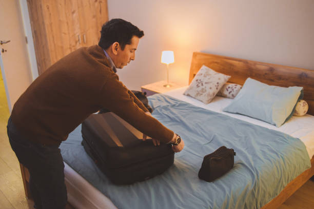 un homme qui fait ses valises pour un voyage - vanity business business person men photos et images de collection