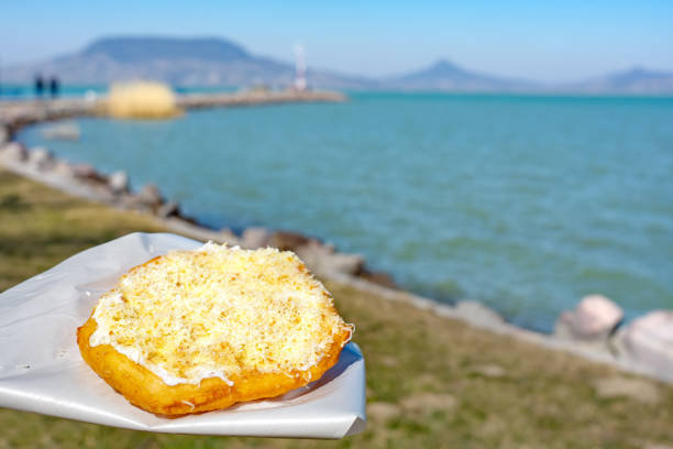 typical hungarian lake Balaton food langos with lake background in Fonyod typical hungarian lake Balaton food langos with lake background in Fonyod . hungarian culture stock pictures, royalty-free photos & images