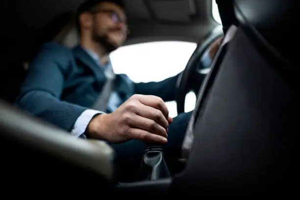 Businessman driving his car ,focus on a gear stick