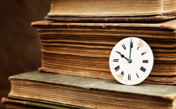 istock Old books and vintage clock face 1386037599