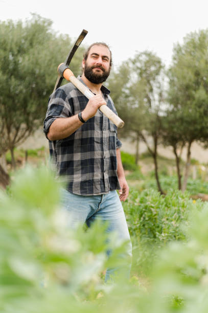 istock Smiling man with axe in countryside 1386037750
