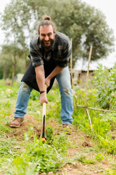 istock Bearded farmer with gardening tools in countryside 1386038298