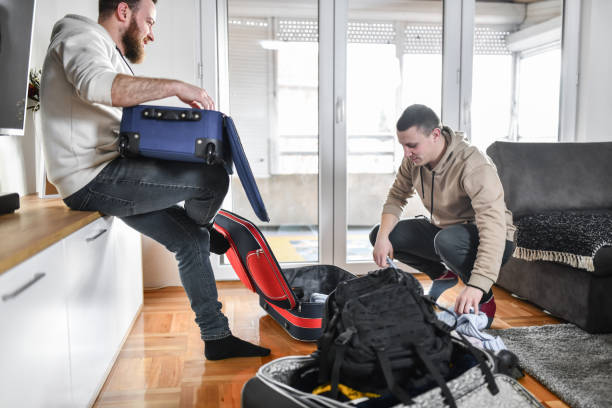istock Two Gay Males Preparing Luggage For Trip 1386038402