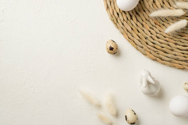 istock Top view photo of easter decorations lagurus flowers round serving mat ceramic easter bunny and easter eggs on isolated white background with empty space 1386040076